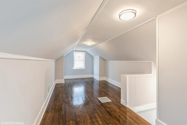 additional living space featuring lofted ceiling, wood finished floors, visible vents, and baseboards