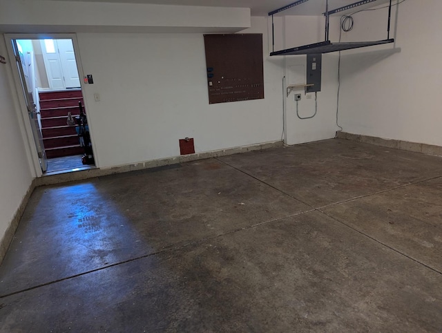 garage featuring electric panel and baseboards