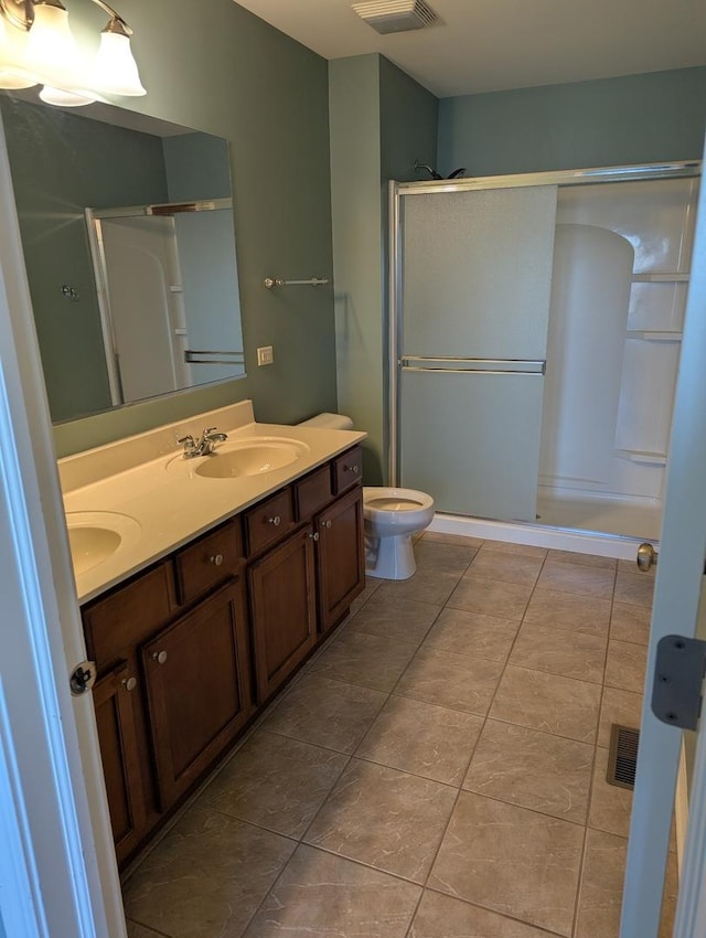 bathroom with double vanity, visible vents, a stall shower, a sink, and tile patterned flooring