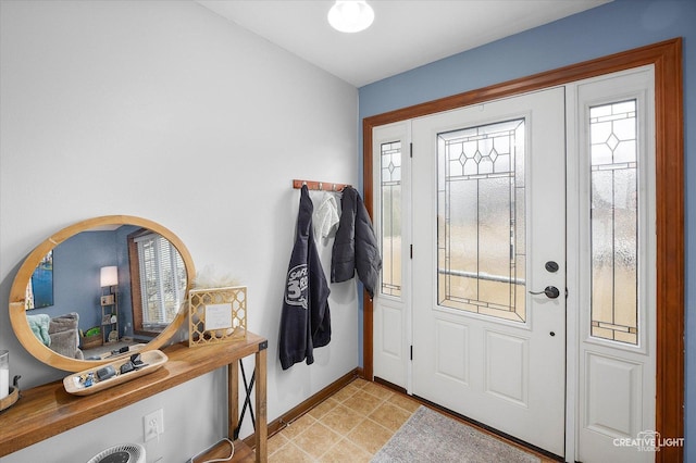 foyer entrance with light tile patterned floors and baseboards