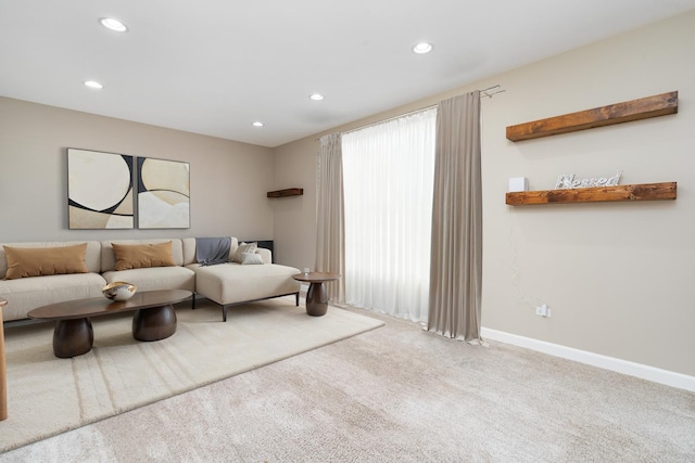 carpeted living area featuring recessed lighting and baseboards