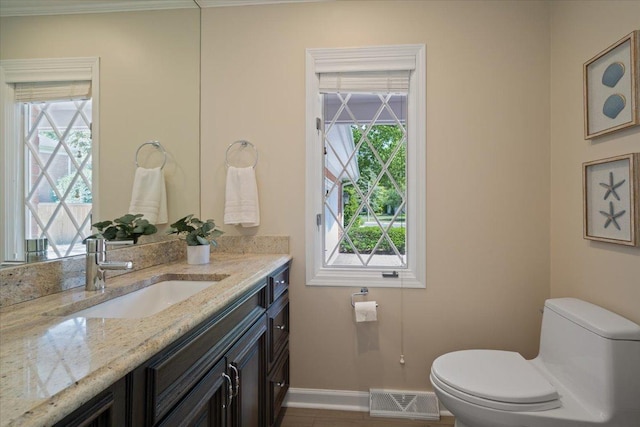 half bathroom with visible vents, baseboards, toilet, and vanity