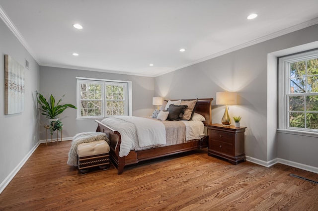 bedroom featuring recessed lighting, crown molding, baseboards, and wood finished floors