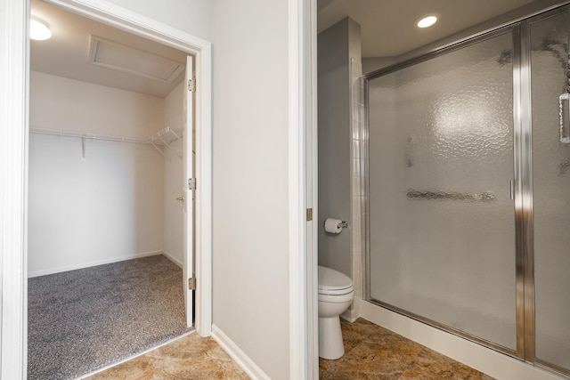 bathroom with baseboards, recessed lighting, a shower stall, a walk in closet, and toilet