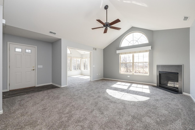 unfurnished living room featuring visible vents, high vaulted ceiling, carpet flooring, and a tile fireplace