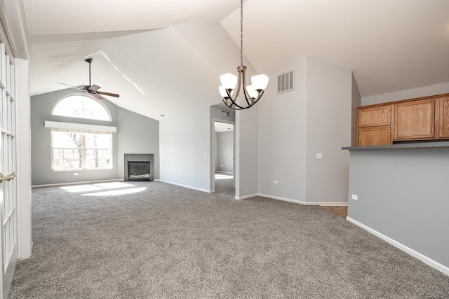 unfurnished living room featuring visible vents, baseboards, carpet flooring, ceiling fan with notable chandelier, and a glass covered fireplace