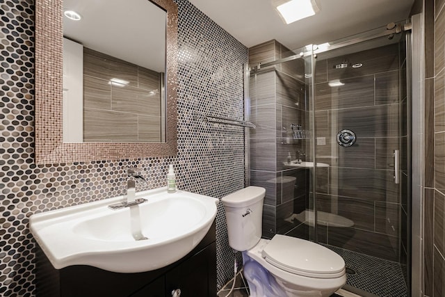 full bath featuring vanity, a stall shower, decorative backsplash, tile walls, and toilet