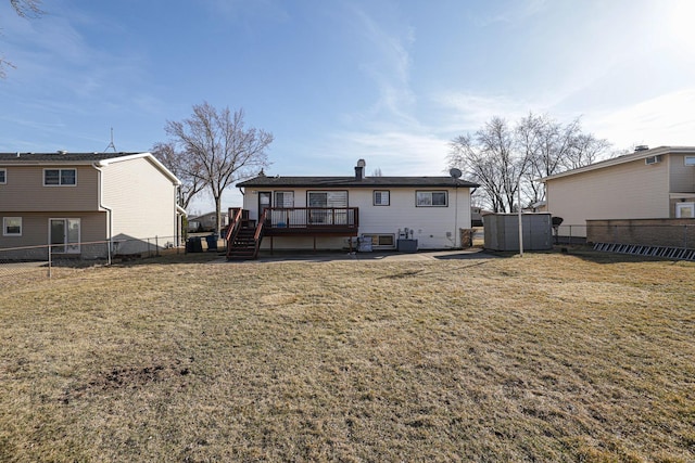 rear view of house featuring a fenced backyard, a yard, and a deck