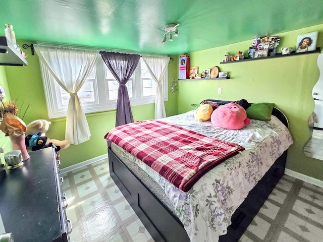 bedroom with light floors and baseboards