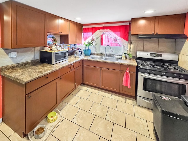 kitchen featuring stainless steel appliances, backsplash, light tile patterned flooring, a sink, and under cabinet range hood