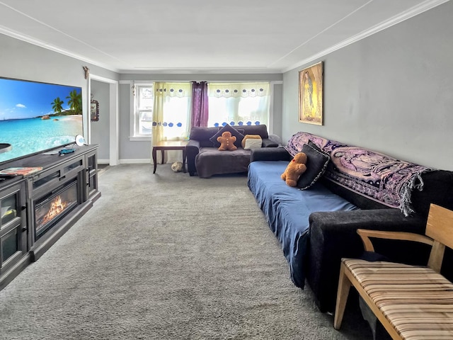 living area featuring carpet floors, a glass covered fireplace, ornamental molding, and baseboards