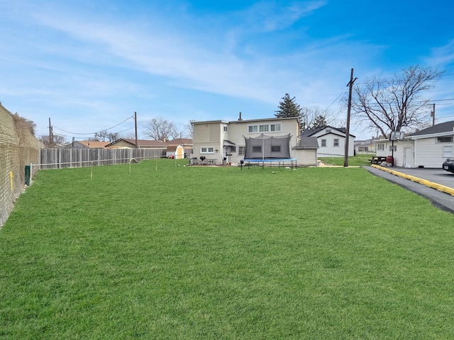 exterior space featuring a trampoline and fence