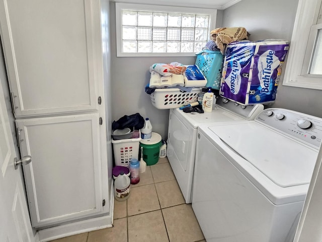 washroom with light tile patterned floors, cabinet space, and washer and dryer