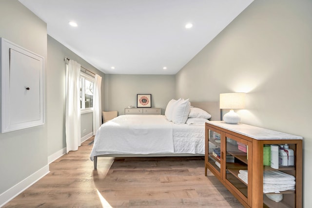 bedroom with baseboards, recessed lighting, and light wood-style floors