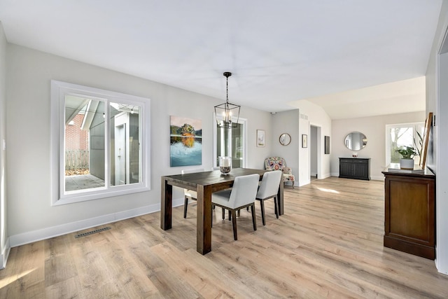 dining space featuring baseboards, an inviting chandelier, visible vents, and light wood-style floors