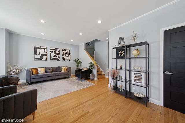 living area featuring stairway, wood finished floors, baseboards, recessed lighting, and crown molding