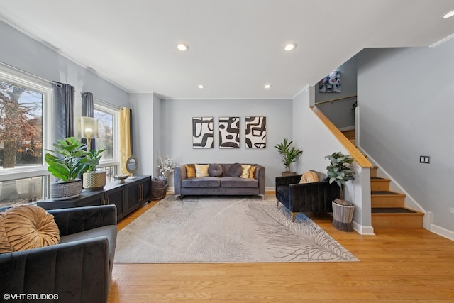 living room with stairs, recessed lighting, light wood-style floors, and baseboards