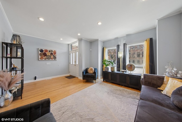 living area featuring recessed lighting, light wood-style flooring, crown molding, and baseboards