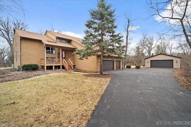 view of front of property with a detached garage, an outbuilding, and a front lawn