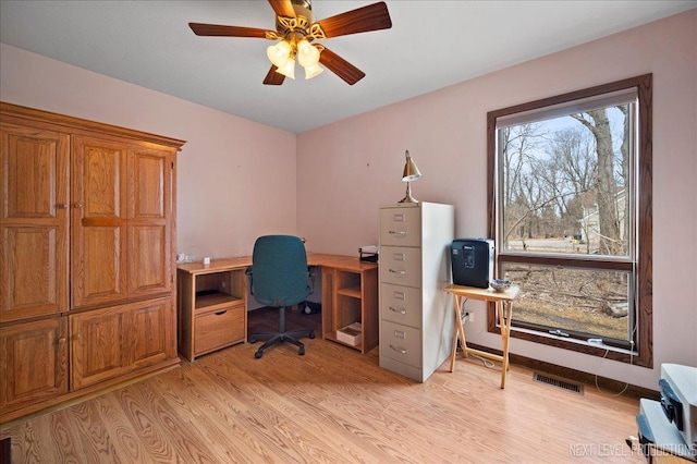 office space with light wood-type flooring, visible vents, baseboards, and ceiling fan