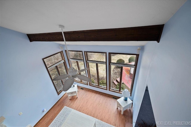 foyer entrance with ceiling fan, visible vents, beam ceiling, and wood finished floors