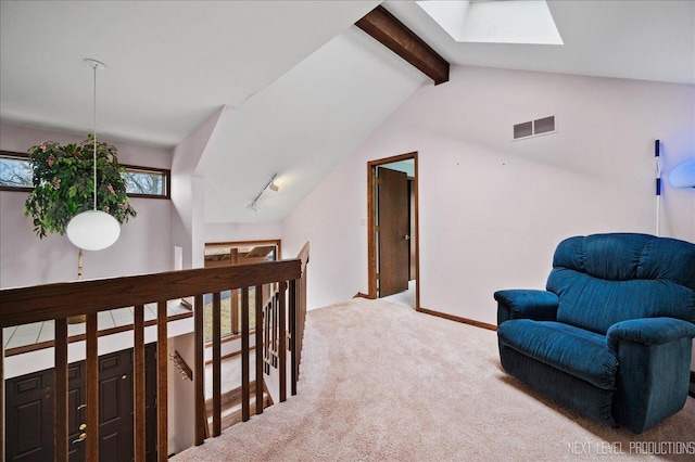 living area with visible vents, baseboards, lofted ceiling with skylight, carpet flooring, and an upstairs landing