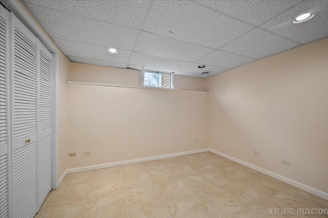 below grade area featuring recessed lighting, baseboards, and a drop ceiling