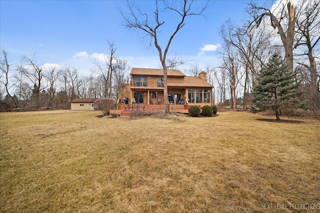 rear view of house with a chimney and a yard