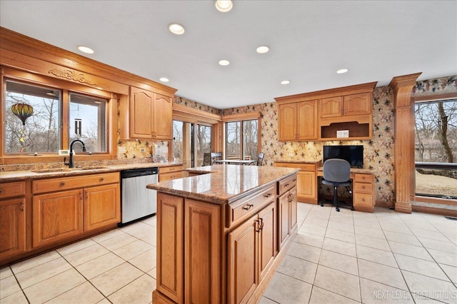 kitchen featuring recessed lighting, dishwasher, light stone countertops, and a sink