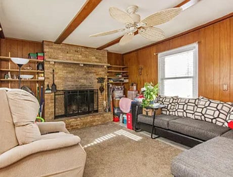 living area with wooden walls and a fireplace