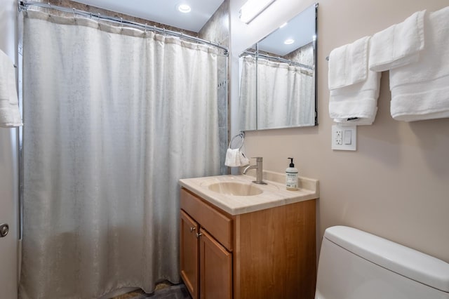 bathroom with a shower with shower curtain, vanity, and toilet