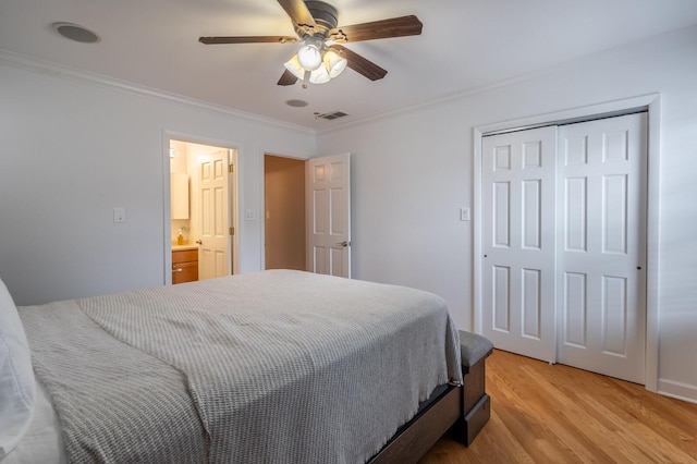 bedroom featuring a closet, visible vents, light wood-style flooring, ornamental molding, and ceiling fan