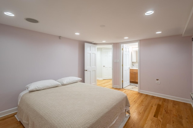 bedroom featuring recessed lighting, light wood-style flooring, baseboards, and ensuite bathroom