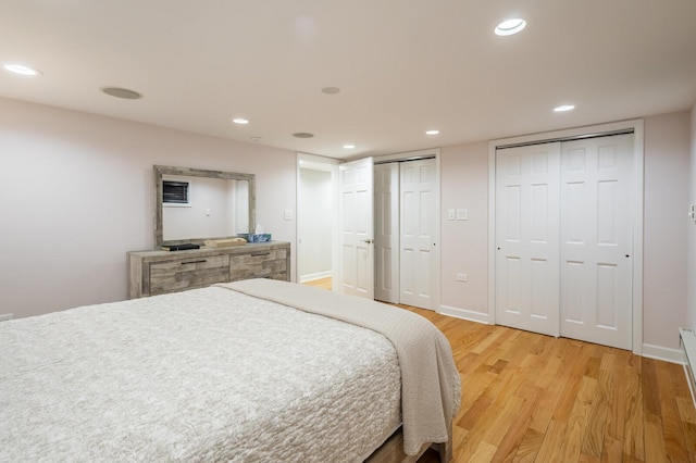 bedroom with light wood-style floors, baseboards, multiple closets, and recessed lighting