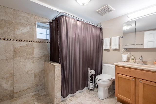 full bathroom with visible vents, vanity, toilet, and tiled shower