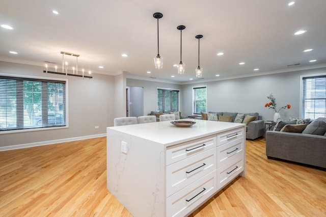 kitchen with open floor plan, light wood finished floors, white cabinetry, and crown molding