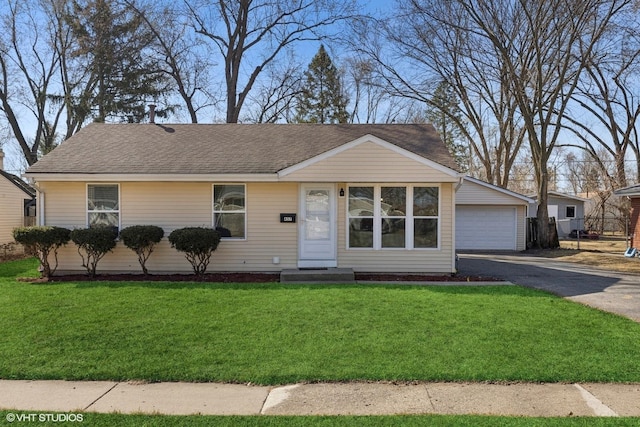 single story home with a detached garage, a front lawn, and fence