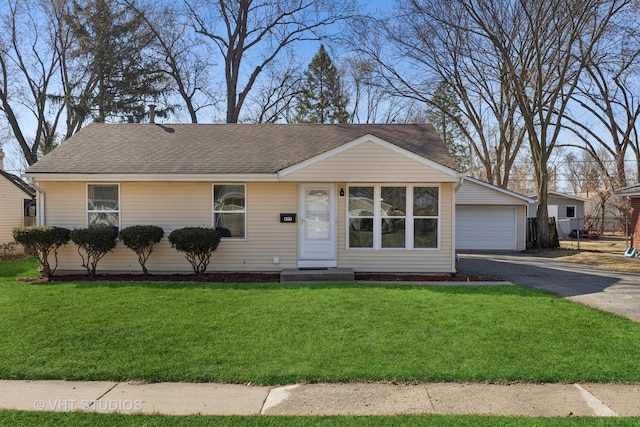 single story home featuring a detached garage and a front yard