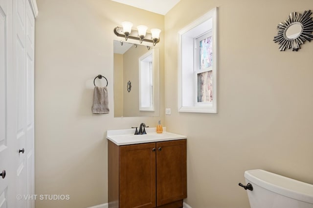 half bathroom with toilet and vanity