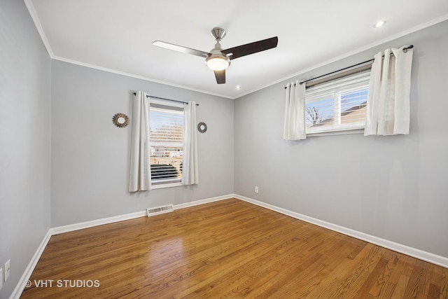 unfurnished room featuring visible vents, baseboards, and ornamental molding