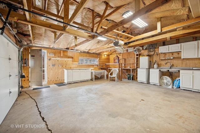 garage featuring a garage door opener and wood walls