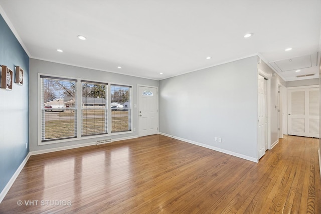 spare room with crown molding, recessed lighting, wood finished floors, and baseboards