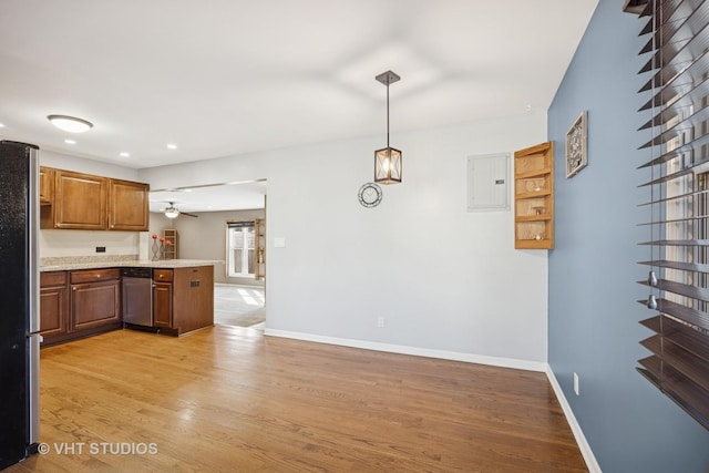 kitchen featuring baseboards, a peninsula, light wood-style flooring, electric panel, and stainless steel appliances