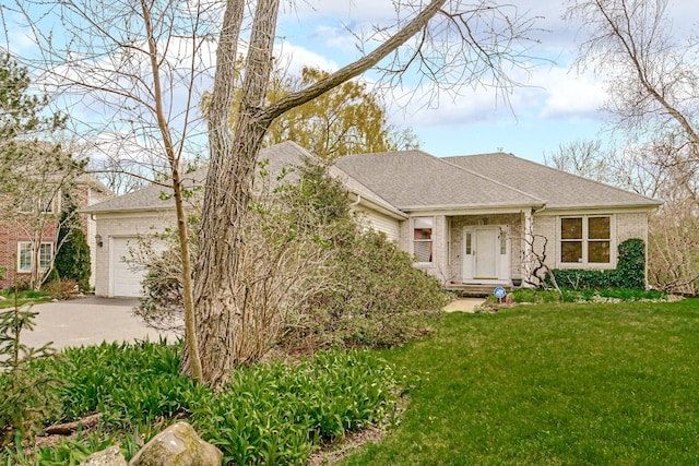 view of front facade featuring roof with shingles, a front lawn, driveway, brick siding, and a garage