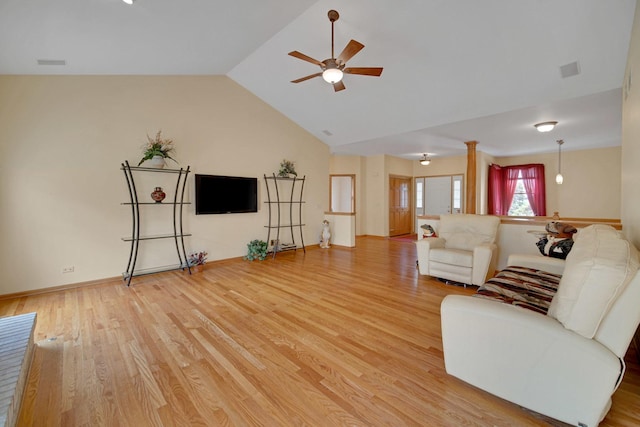 living room featuring light wood finished floors, lofted ceiling, visible vents, and a ceiling fan