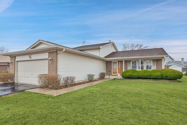 view of front of house with a garage, a front yard, brick siding, and driveway