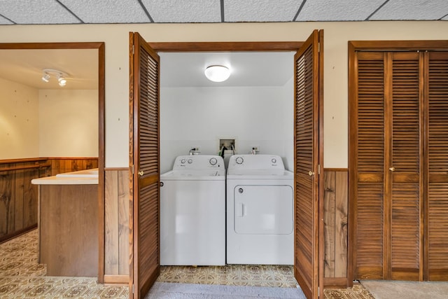 laundry room with wainscoting, wooden walls, washing machine and dryer, and carpet floors