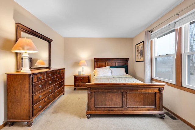 bedroom featuring baseboards, visible vents, and light carpet