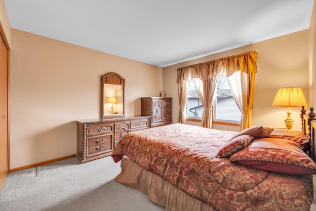 bedroom with baseboards and light colored carpet