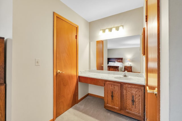 ensuite bathroom featuring vanity, ensuite bathroom, and baseboards